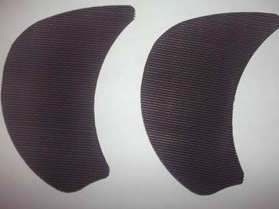 There are two kidney-shaped extruder screen made from black wire cloth.