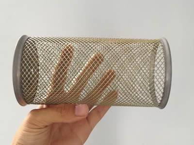 There is a expanded metal extruder screen tube in one hand.