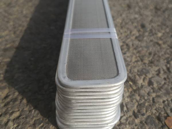 Mehrere Stücke schmelz geblasener Spinneret-Filter netze zeigen die Details des Aluminium rahmens.