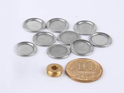 There are several extruder screen discs with a coin beside them.