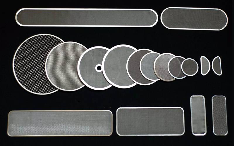 Several different shapes of spinneret filter meshes on the black background.